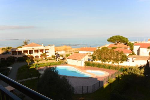 - une vue sur une maison et une piscine dans l'établissement Palmeraie 406- vue piscine- clim- proche plage et commerces, à Sari-Solenzara