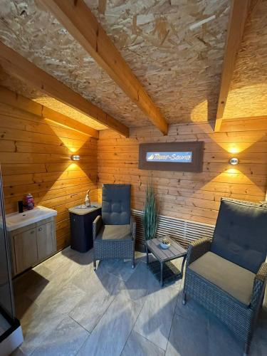 a living room with two chairs and a sink at Winkelschiffchen II mit Sauna in Juist