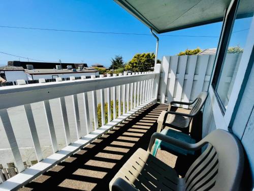 a balcony with two chairs and a fence at Seabird Lodge Fort Bragg in Fort Bragg