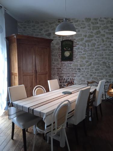 une salle à manger avec une table et des chaises dans l'établissement Maison de famille à Périgueux, à Périgueux