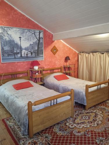 - 2 lits dans une chambre aux murs rouges dans l'établissement Maison de famille à Périgueux, à Périgueux