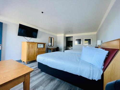 a hotel room with a large bed and a television at Seabird Lodge Fort Bragg in Fort Bragg