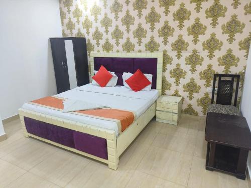a bedroom with a bed with red pillows and a telephone at HOTEL ASHOKA PALACE Near IGI Airport New Delhi in New Delhi
