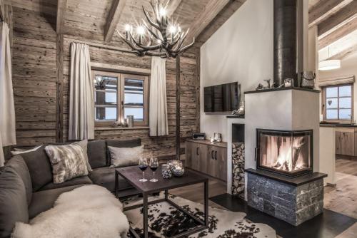 a living room with a couch and a fireplace at Aadla Walser-Chalets mit privater Sauna, Hotpot und Hotelservice in Schröcken