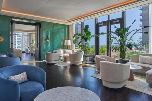 a lobby with chairs and tables and windows at The St. Regis Chicago in Chicago