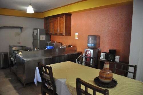 uma cozinha com uma mesa e uma cozinha com um balcão em Hotel Ecológico Temazcal em Creel