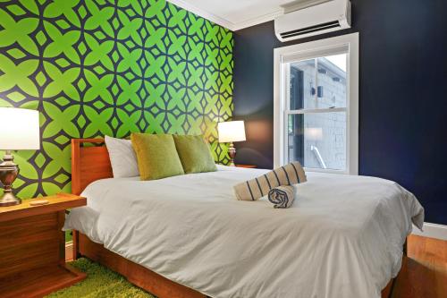 Un dormitorio con una cama con una pared verde. en Cape Cod Mod, en Provincetown