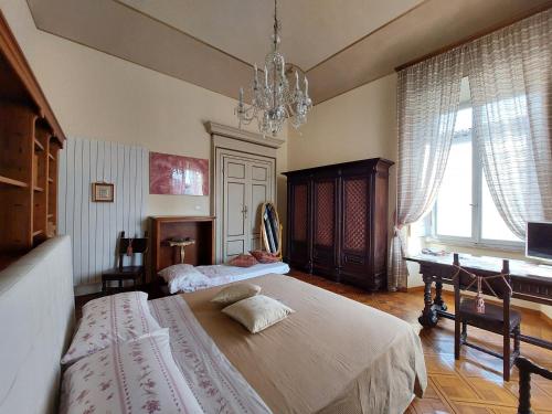1 dormitorio con 2 camas y lámpara de araña en Luxury B&B '700, en Ascoli Piceno