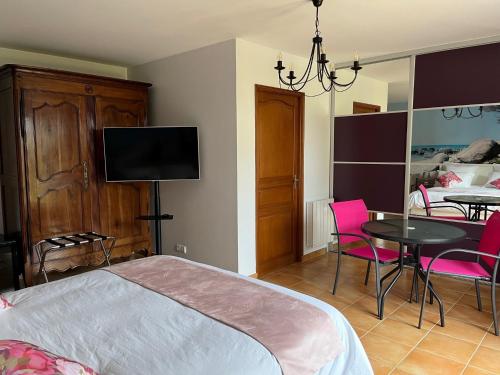1 dormitorio con cama y mesa con sillas rosas en Ô Mélèze en Morsang-sur-Orge