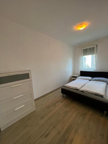 a bedroom with a bed and a dresser in it at Kristály Apartman in Szeged