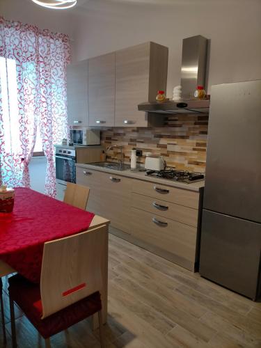 a kitchen with a red table and a refrigerator at Cherry's house in Celleno