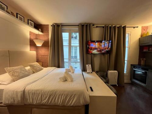 - une chambre avec un ours en peluche blanc assis sur un lit dans l'établissement Studio Pompidou - rue des Temples 3 places, à Paris