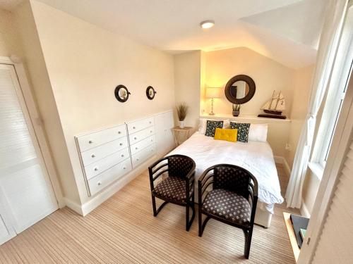 a bedroom with a bed and two chairs at Holland House in New Brighton