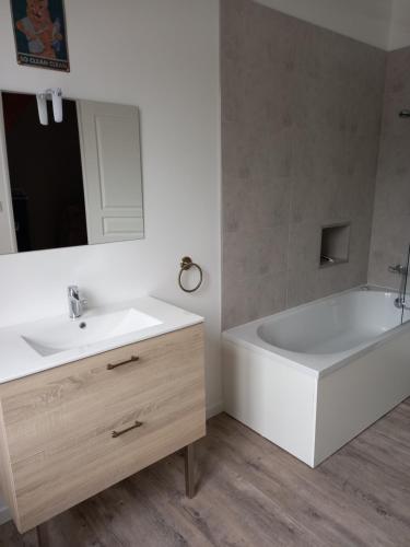 baño con bañera blanca y lavabo blanco en Chez Sindy et Olivier, en Crèvecoeur-le-Grand