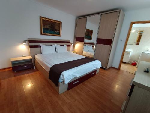 une chambre avec un grand lit et un miroir dans l'établissement Central Park Apartments, à Braşov