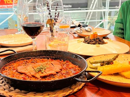 a table topped with a pan of food and wine at Hotel Indigo Madrid - Gran Vía by IHG in Madrid