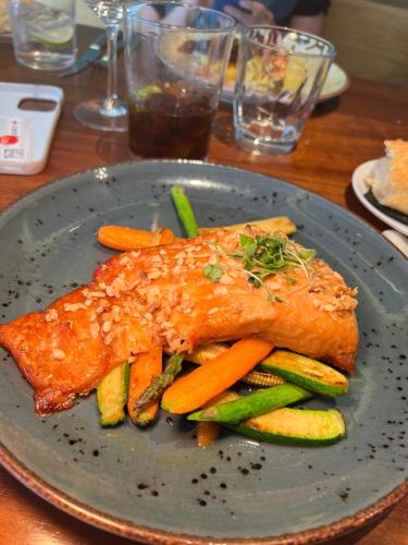 a plate of food with fish and vegetables on a table at Hotel Indigo Madrid - Gran Vía by IHG in Madrid
