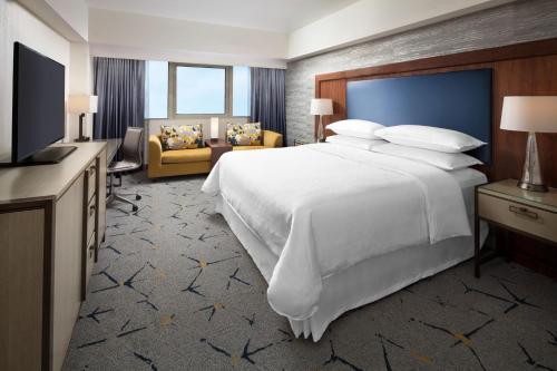 a hotel room with a large bed and a television at Sheraton Gateway Los Angeles Hotel in Los Angeles