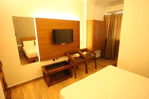 um quarto de hotel com um espelho e uma cama em Whitehouse Residency em Palakkad
