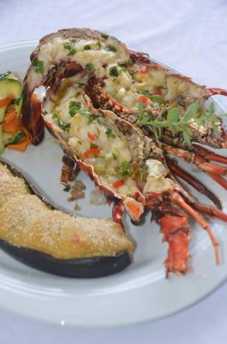 a white plate of food with a lobster on it at kaï colibri in Rivière-Pilote