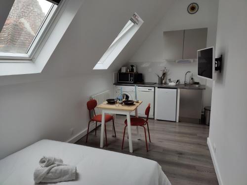 eine kleine Küche mit einem Tisch und Stühlen in einem Zimmer in der Unterkunft Studio passage des arts - Vieux Lille in Lille