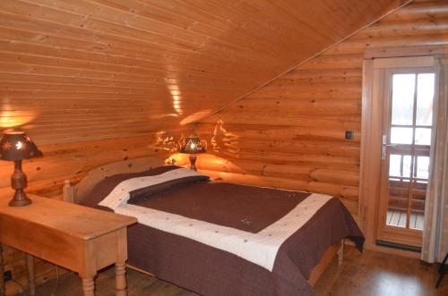 - une chambre avec un lit dans une cabane en rondins dans l'établissement LE MARLOTTE, à Sapois