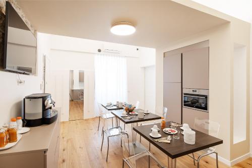 een keuken en een woonkamer met 2 tafels en stoelen bij Duomo B&B in Teramo