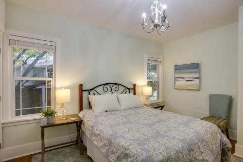 a bedroom with a bed and a window and a chandelier at Downtown Coeur dAlene Retreat Near Lake and Parks! in Coeur d'Alene