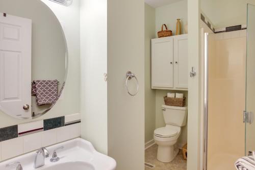 a bathroom with a toilet and a sink and a mirror at Downtown Coeur dAlene Retreat Near Lake and Parks! in Coeur d'Alene