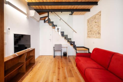 a living room with a red couch and a staircase at Duomo B&B in Teramo