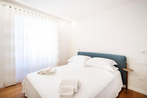 a bedroom with a white bed with towels on it at Duomo B&B in Teramo