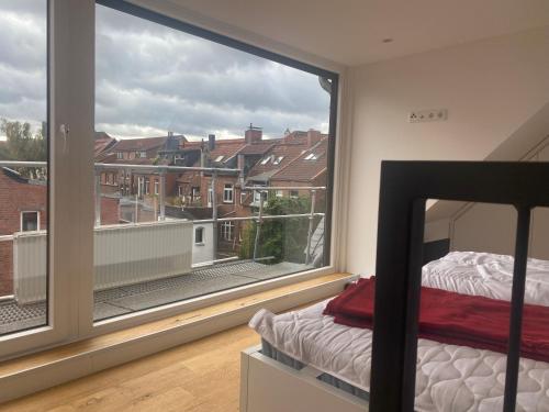 Schlafzimmer mit einem großen Fenster, einem Bett und einem Balkon in der Unterkunft Exklusive Unterkunft in Hannover