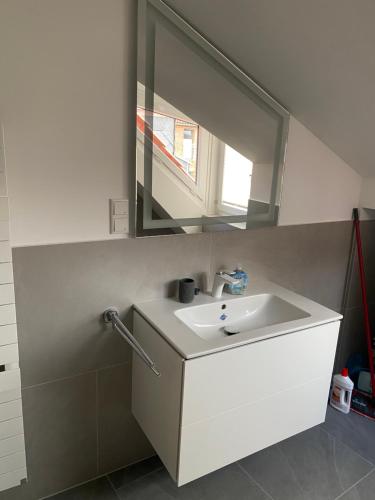 W łazience znajduje się biała umywalka i lustro. w obiekcie Exklusive Unterkunft w Hanowerze