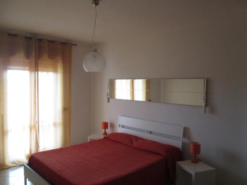 a bedroom with a red bed and a mirror at Casa Velina in Castelnuovo Cilento