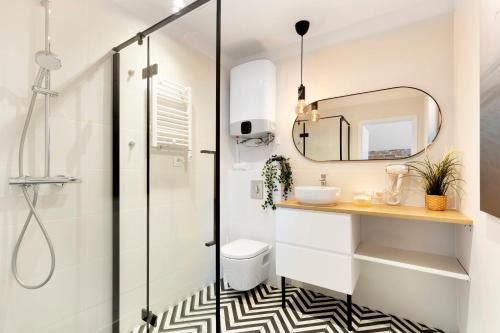 a bathroom with a shower and a sink and a mirror at Elite Apartments Old Town Długi Targ in Gdańsk