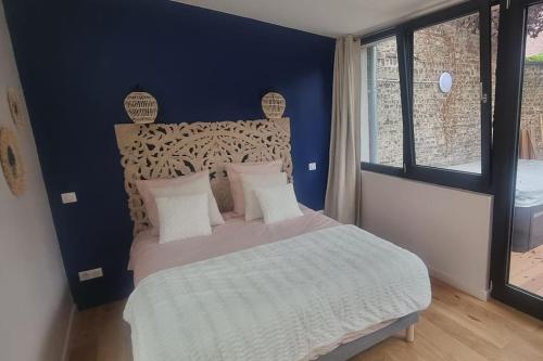 1 dormitorio con 1 cama grande y pared azul en Les Spas du Sébasto, en Lille