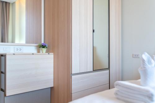 Ban SuanにあるThe Lago Apartmentsのバスルーム(鏡付きの木製クローゼット付)