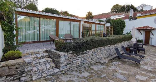 a patio with chairs and a stone wall at Hotel Real d Obidos in Óbidos