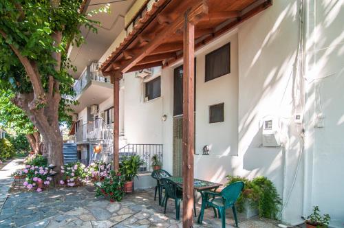 un patio con mesa y sillas junto a un edificio en Apartments Xara, en Velika