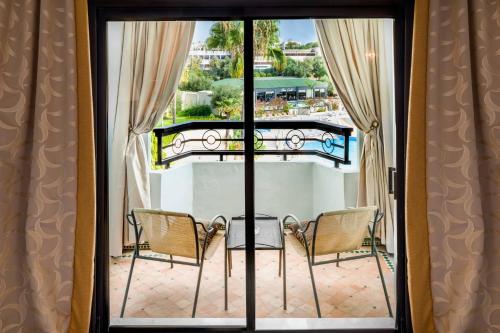 a view of a balcony with two chairs and a table at Fes Marriott Hotel Jnan Palace in Fès