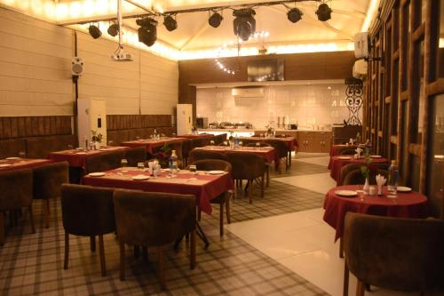 a restaurant with tables and chairs with red table cloth at Hotel Gurveer Royal in Lucknow