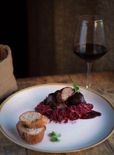 a plate of food and a glass of wine at Hotel & Restaurant Casolare Le Terre Rosse in San Gimignano
