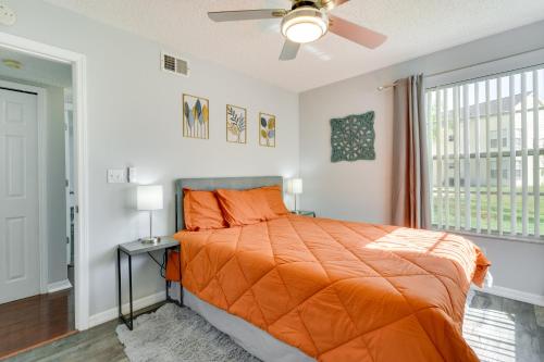 1 dormitorio con 1 cama con edredón de naranja y ventana en Kissimmee Condo with Perks 6 Mi to Disney World!, en Kissimmee