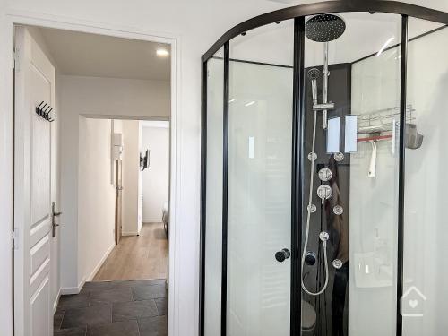 a glass shower door in a room with a hallway at Les studios d'Elina - Entrée autonome in Châtellerault