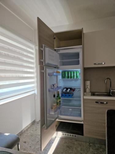 ラーシュコにあるApartmaji PR' KERINのキッチンにあるドアが開いたままの空の冷蔵庫