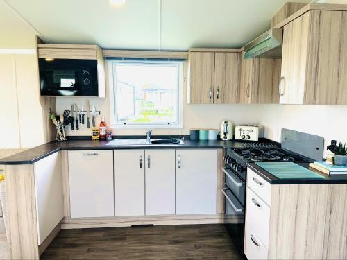 a kitchen with white cabinets and a stove top oven at Adelfas in Scarborough