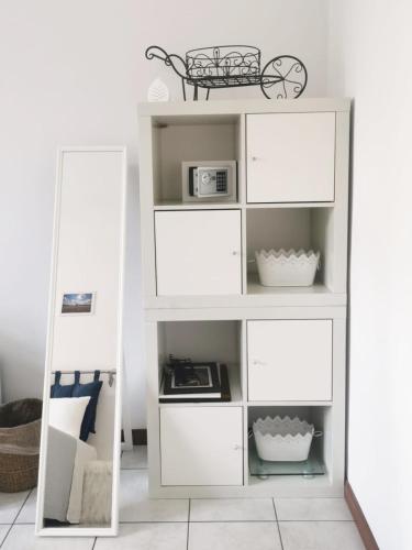 a white shelf with a mirror in a room at Room in shared apartment, near Lecco in Calolziocorte