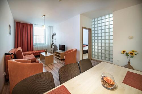 a living room and dining room with a table and chairs at Hotel Spolcentrum in Svit