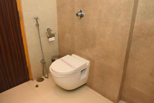 a bathroom with a toilet with a towel on the seat at Hotel Gurveer Royal in Lucknow