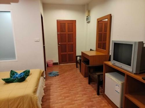 een woonkamer met een tv en een bed en een televisie bij N.D.Hotel in Koh Lanta